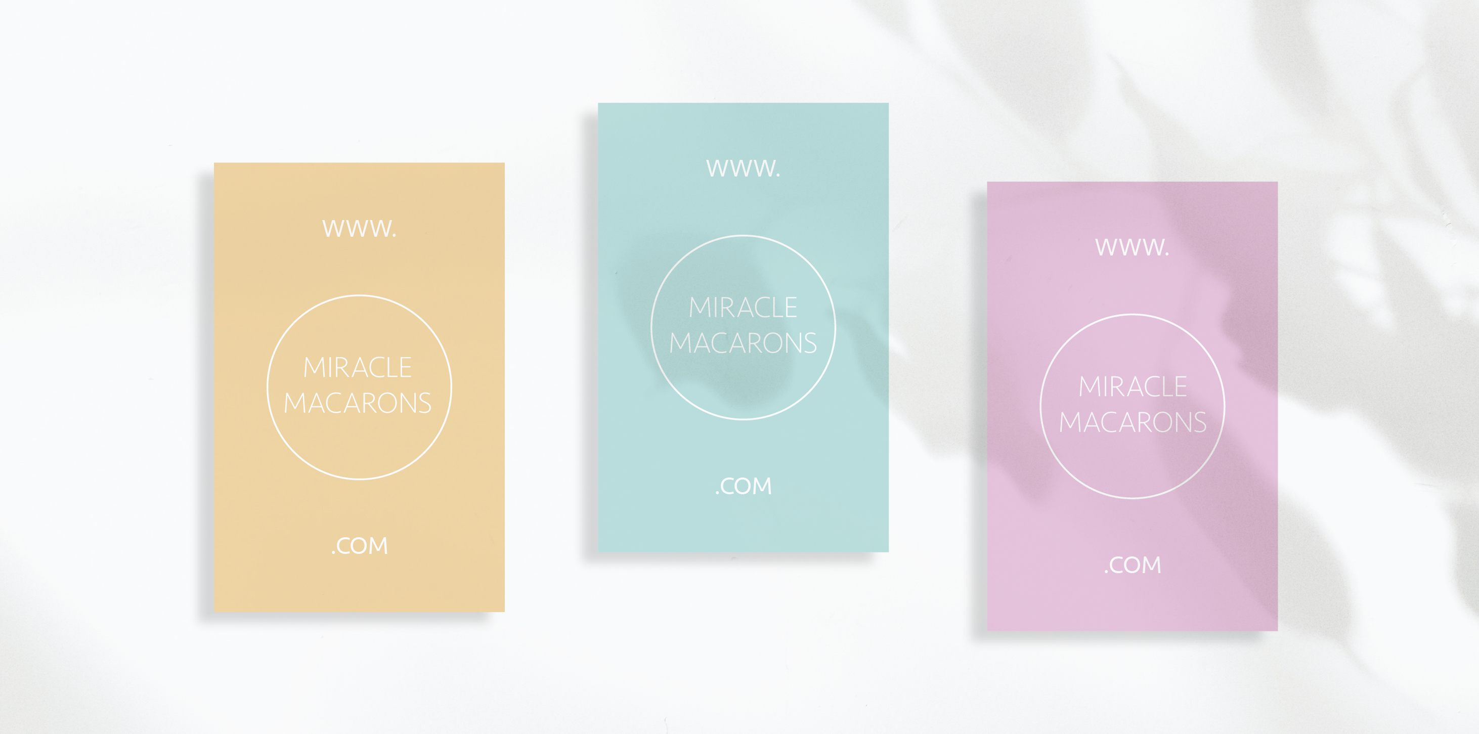Minimalismus Beispiel: Visitenkarte für Miracle Macarons in drei Pastelltönen - die einzige Info ist das Logo, was durch die Textergänzung www. und .com gleichzeitig als Webadresse fungiert